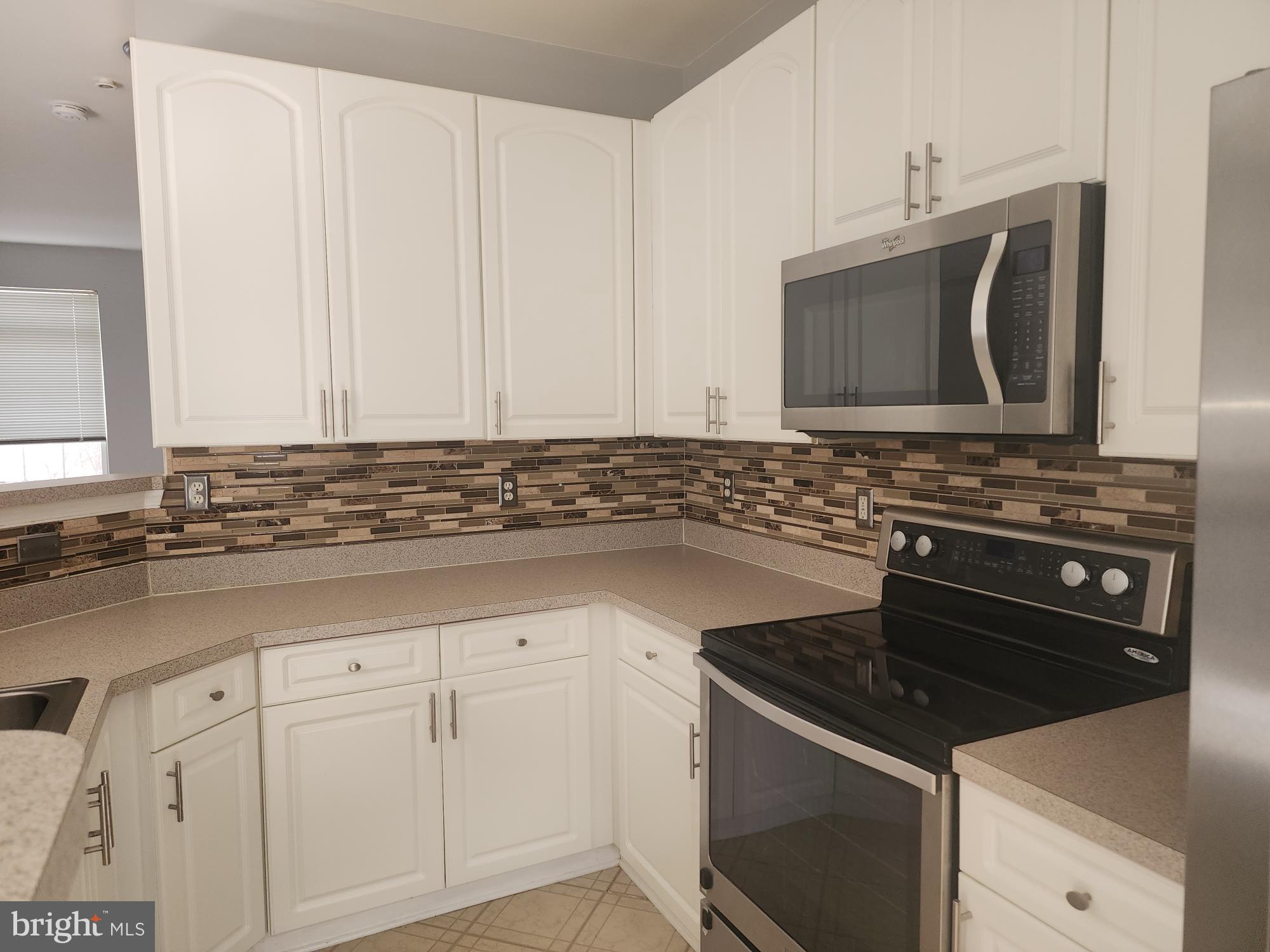 556 Rhapsody Court Hunt Valley, MD 21030 - Photo 17 of 38 a kitchen with granite countertop white cabinets and stainless steel appliances