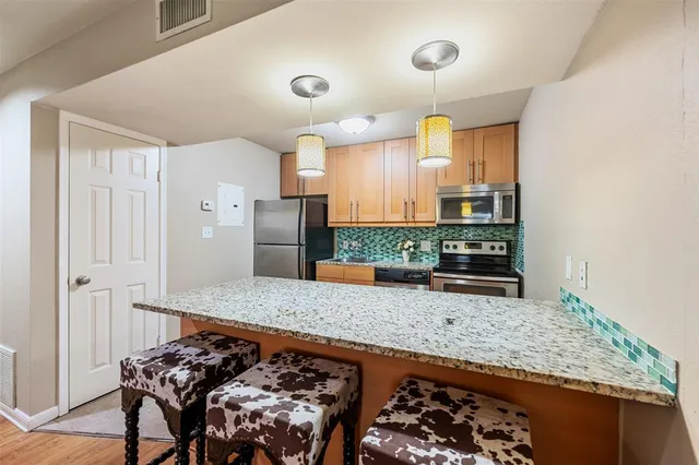 a kitchen with stainless steel appliances granite countertop a stove a sink and a microwave