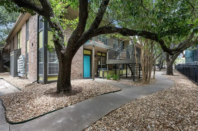 a view of an empty room with wooden floor fireplace and a window
