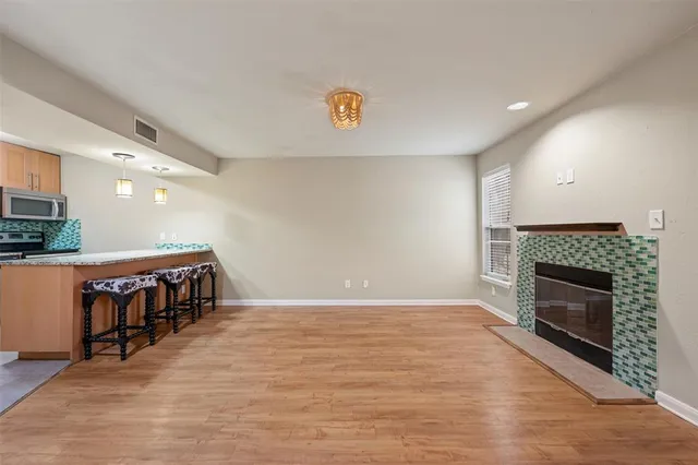 a view of empty room with wooden floor and fireplace