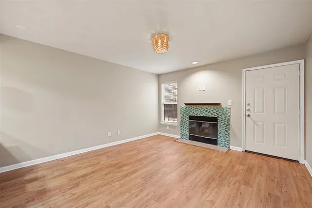 an empty room with wooden floor and fireplace