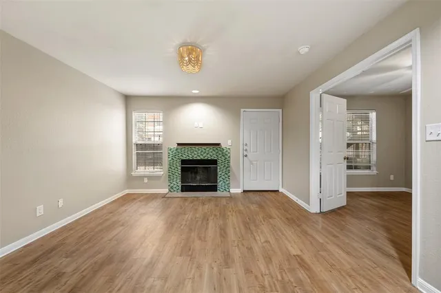 a view of empty room with wooden floor and fireplace
