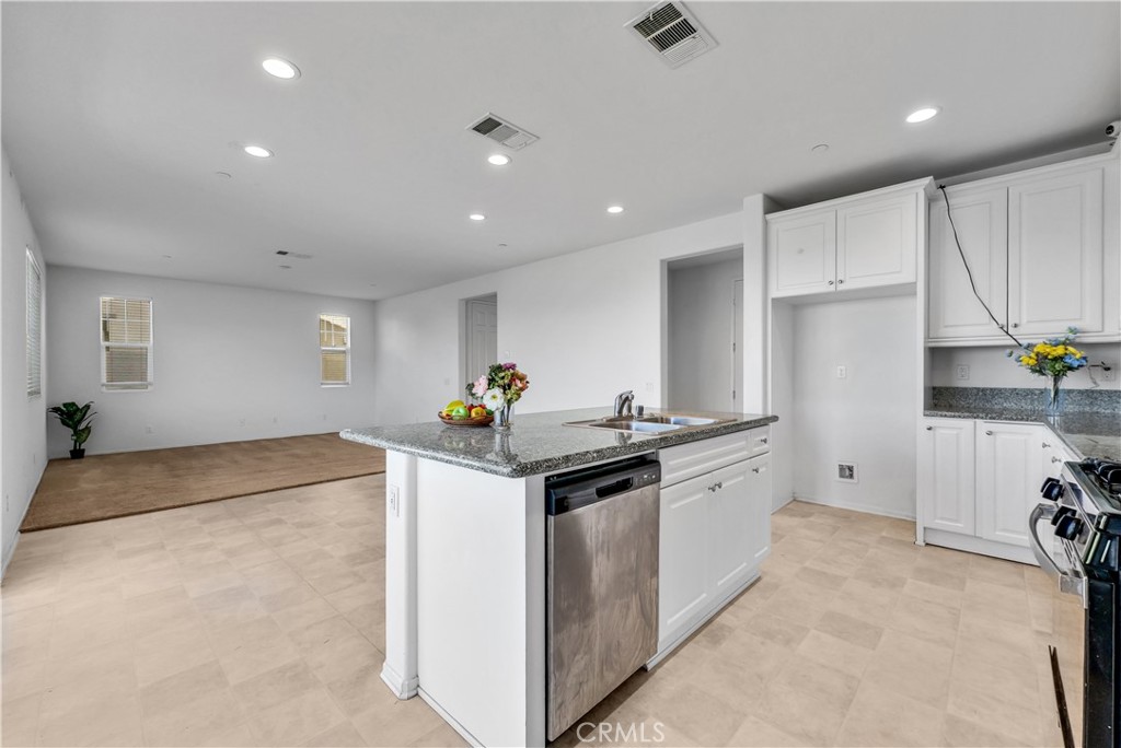 29157 Sunforest Lake Elsinore, CA 92530 - Photo 13 of 39 a kitchen with granite countertop a sink stove and refrigerator