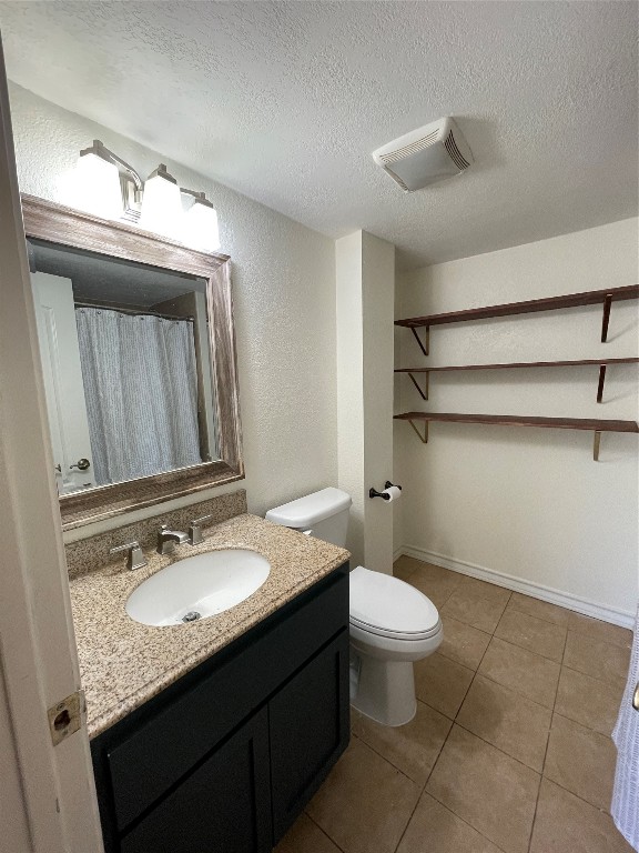 1303 Pendergrass Street Lockhart, TX 78644 - Photo 3 of 16 a bathroom with a granite countertop sink a toilet and a mirror