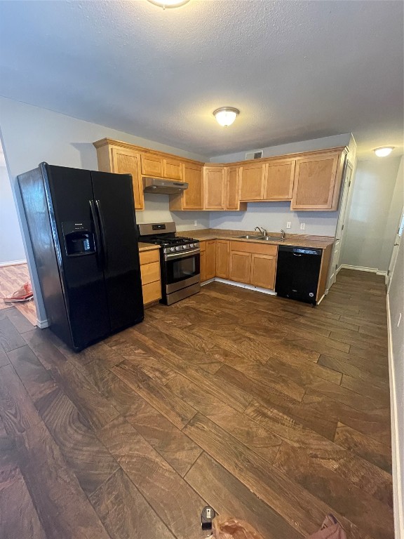 1303 Pendergrass Street Lockhart, TX 78644 - Photo 7 of 16 a kitchen with granite countertop a refrigerator and a stove top oven