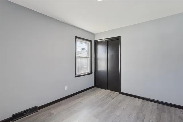 an empty room with windows and closet