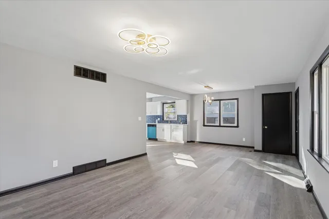 a view of empty room with wooden floor and window