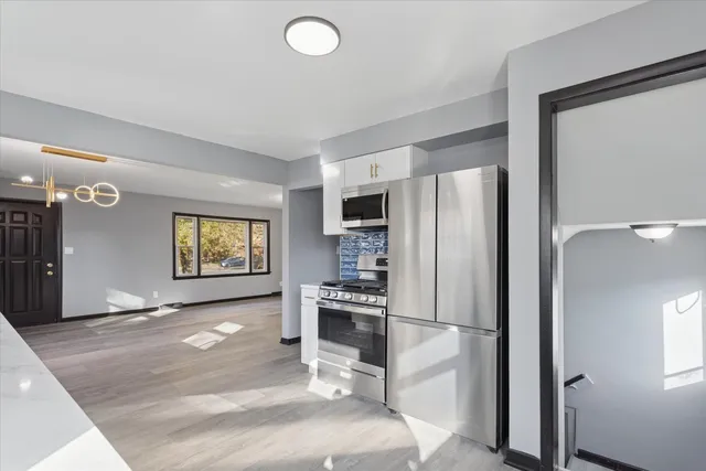 a kitchen with stainless steel appliances granite countertop a refrigerator and a stove top oven