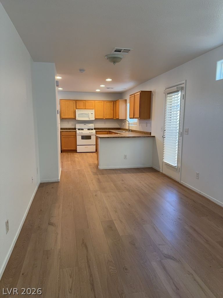 4790 Pinon Pointe Road Las Vegas, NV 89115 - Photo 3 of 16 A well-lit kitchen with warm wood cabinetry overlooks a versatile living space.