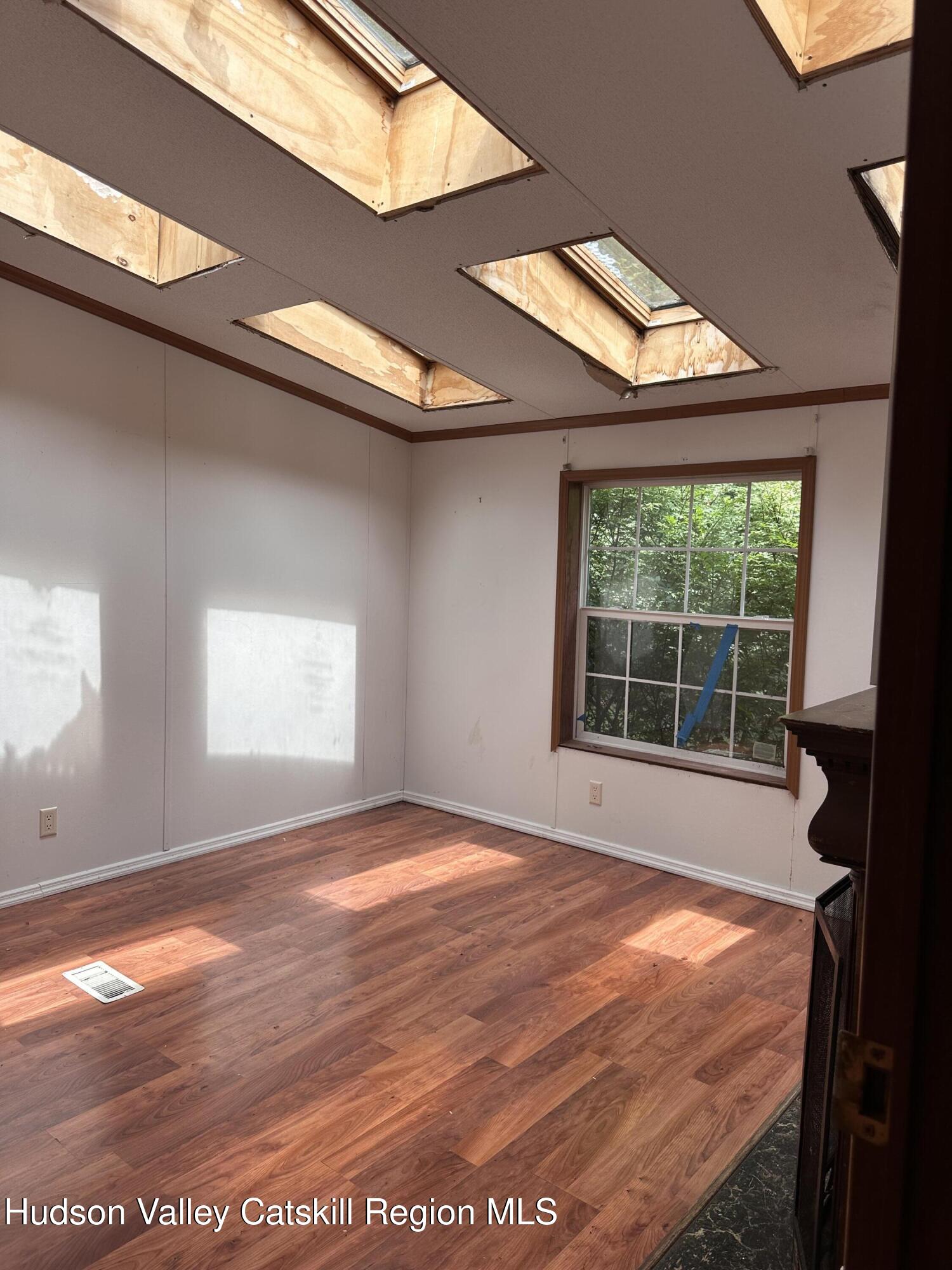 166 Falls View Lane Purling, NY 12470 - Photo 20 of 26 a view of an empty room with wooden floor and a window