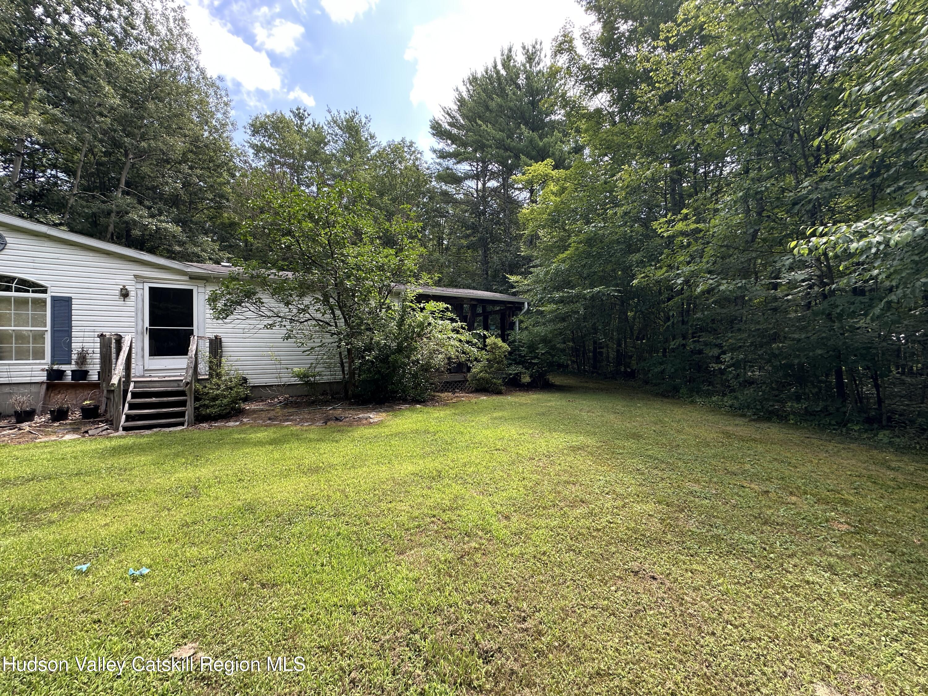 166 Falls View Lane Purling, NY 12470 - Photo 2 of 26 a view of a patio with table and chairs under an umbrella