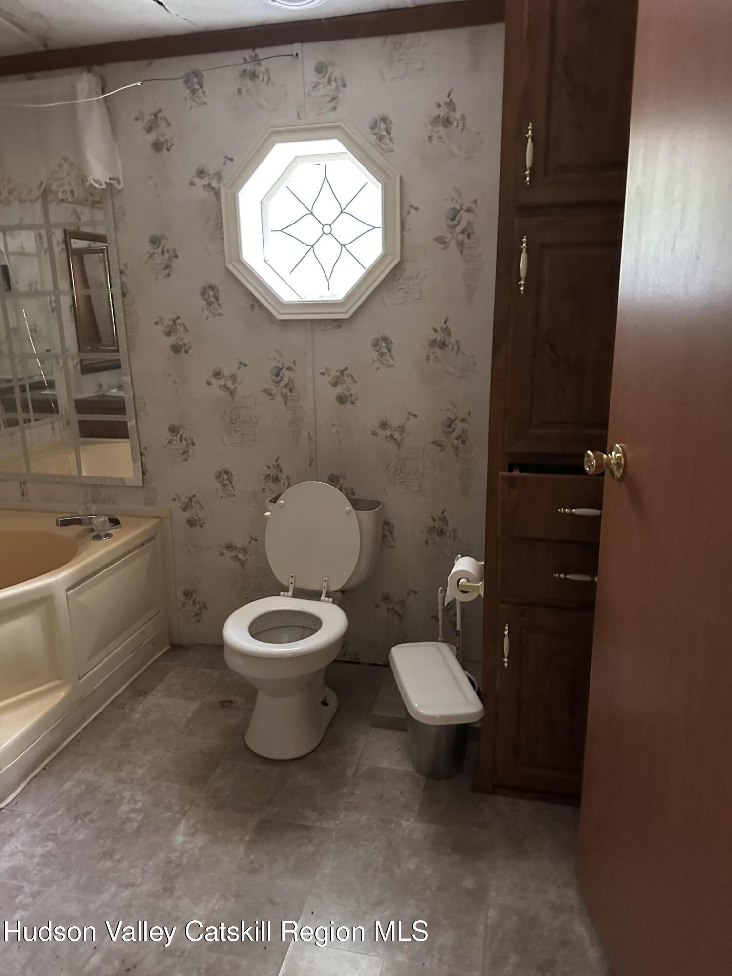 166 Falls View Lane Purling, NY 12470 - Photo 22 of 26 a bathroom with a toilet a sink and mirror