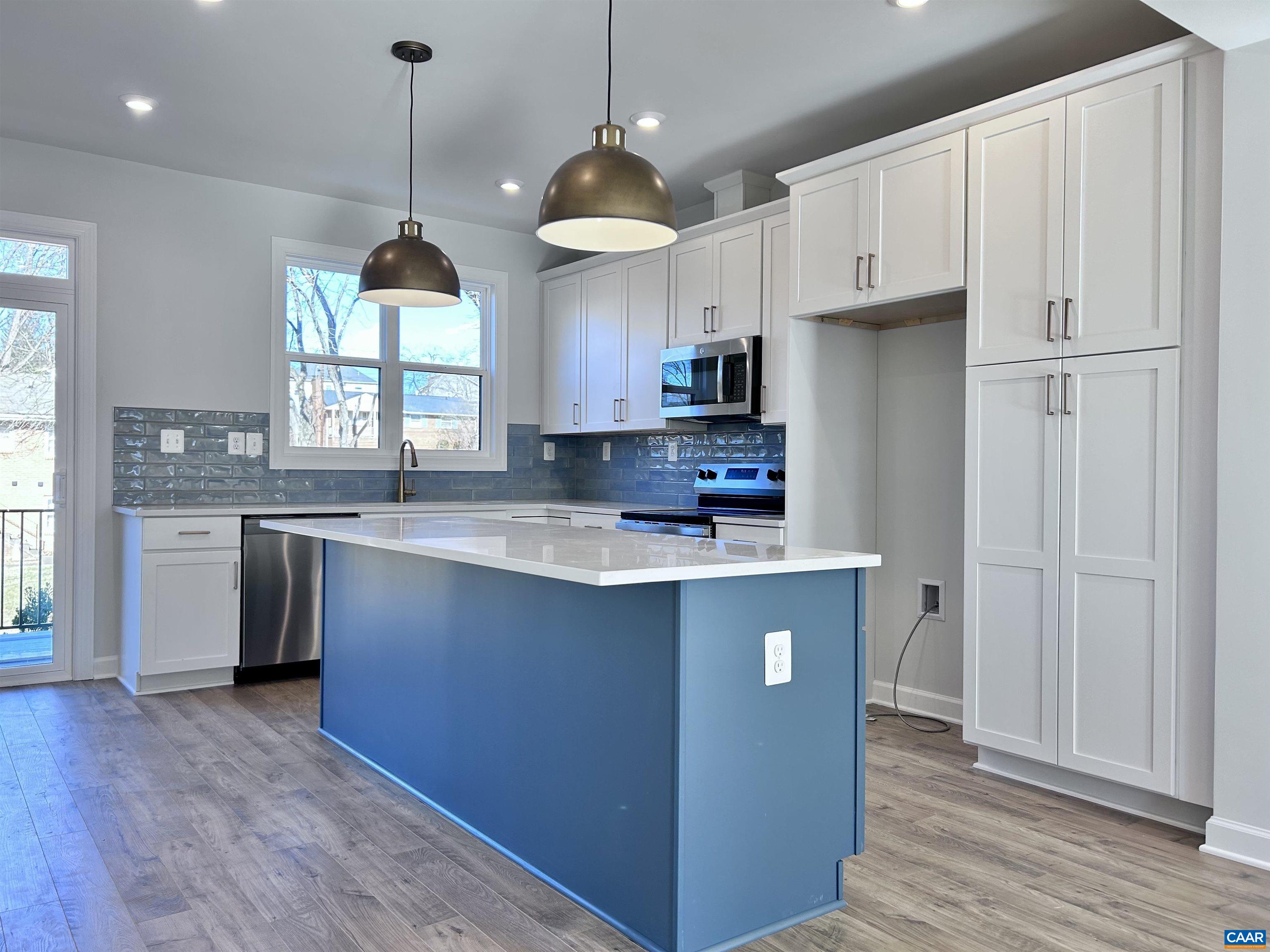 103 Keene Court Charlottesville, VA 22903 - Photo 6 of 18 a kitchen with kitchen island granite countertop a stove a sink a center island and wooden floor