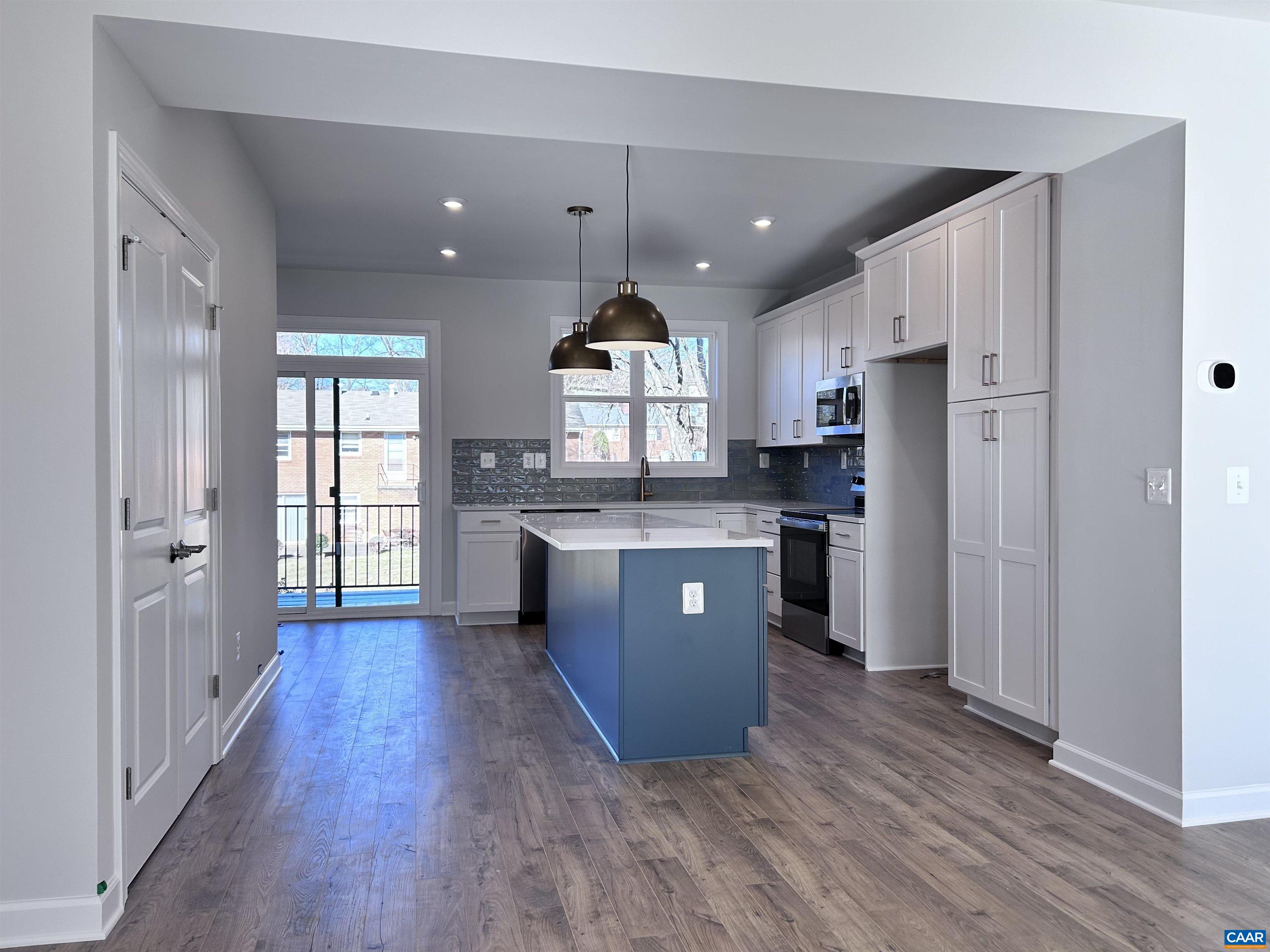 103 Keene Court Charlottesville, VA 22903 - Photo 7 of 18 a large kitchen with stainless steel appliances kitchen island a large counter top and wooden floors