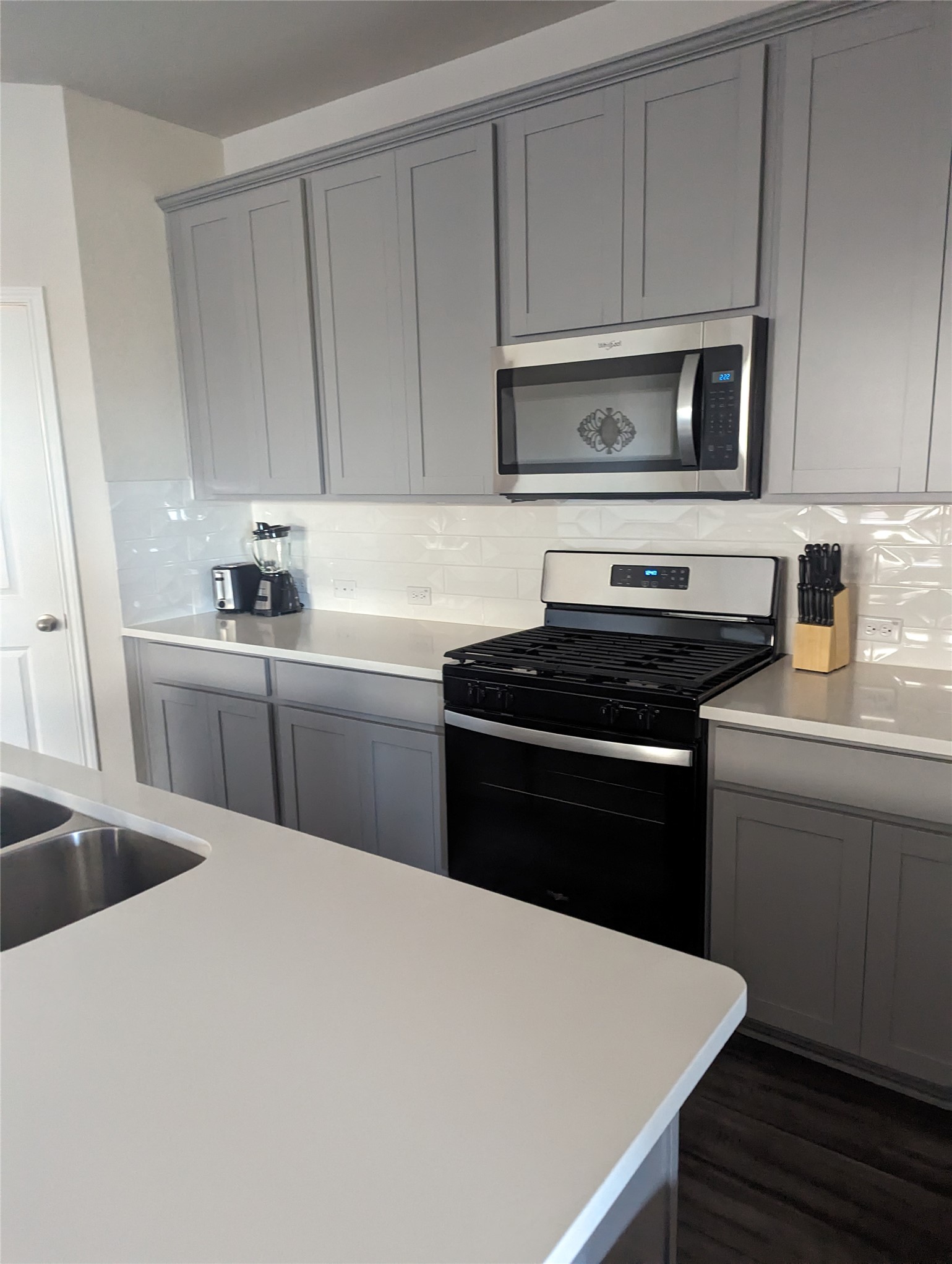 6400 Rounded Pebble Lane Buda, TX 78610 - Photo 27 of 34 a kitchen with a sink a stove and microwave