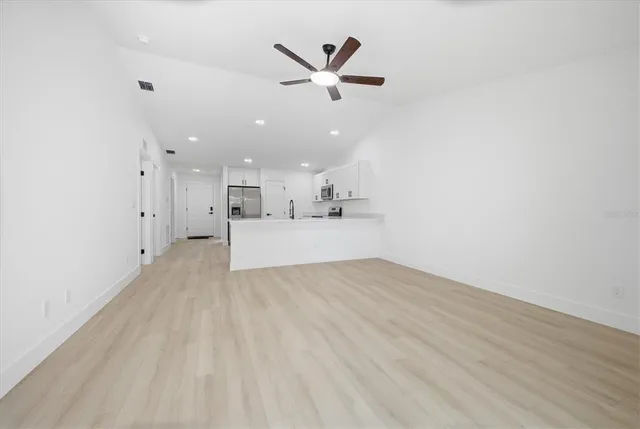a view of a livingroom with a kitchen counter top space and wooden floor