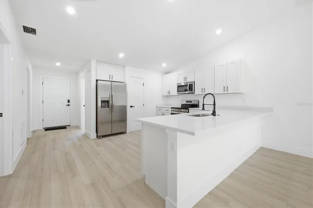 a view of a kitchen with a sink and a refrigerator
