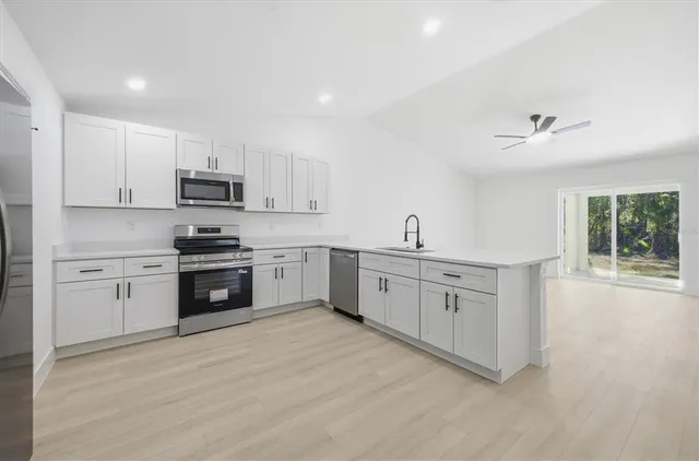 a kitchen with appliances a sink and cabinets