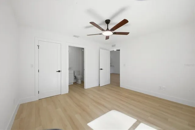 a view of a big room with wooden floor and windows