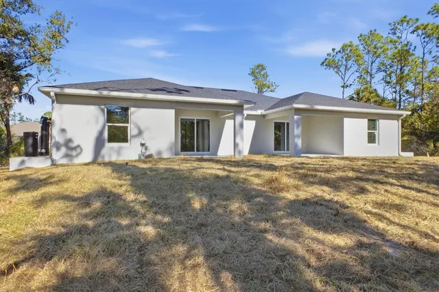 a view of a yard with plants and trees