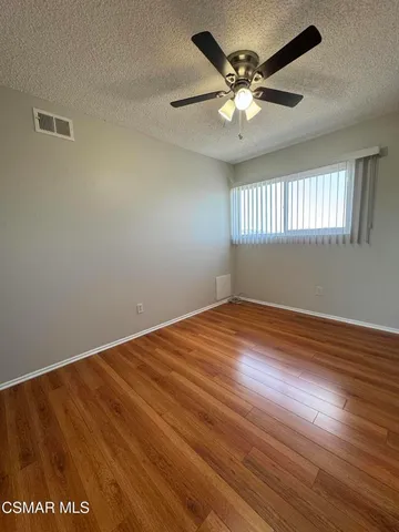 a view of room with hardwood floor and ceiling fan