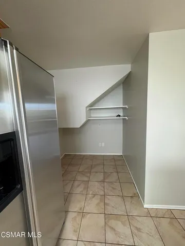 a view of a refrigerator in kitchen and empty room