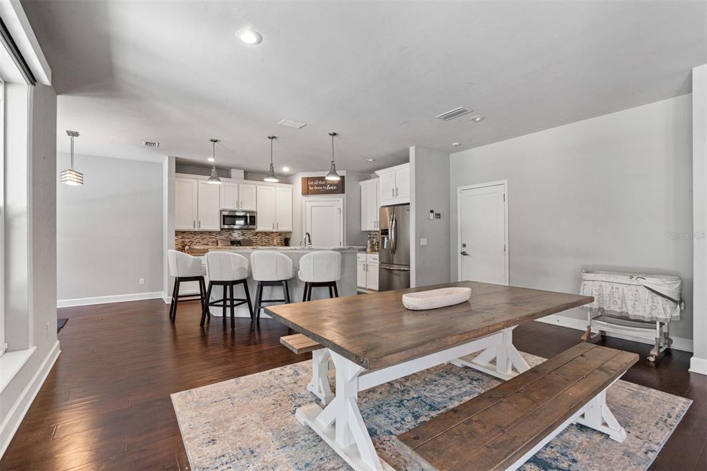 4855 Southwest 64th Road Gainesville, FL 32608 - Photo 15 of 44 a living room with dining table and wooden floor
