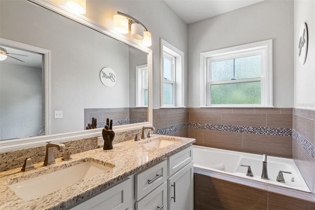 4855 Southwest 64th Road Gainesville, FL 32608 - Photo 31 of 44 a bathroom with a granite countertop sink and a mirror