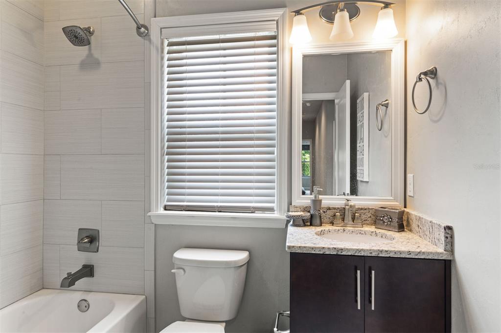 4855 Southwest 64th Road Gainesville, FL 32608 - Photo 35 of 44 a bathroom with a granite countertop sink and a bathtub