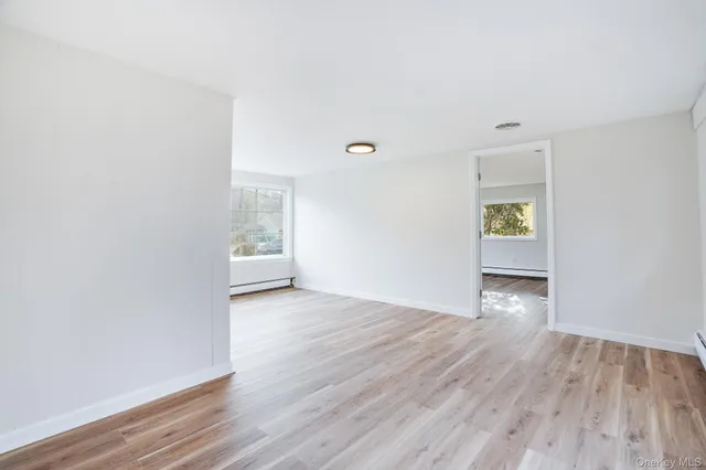 a view of a room with wooden floor and windows