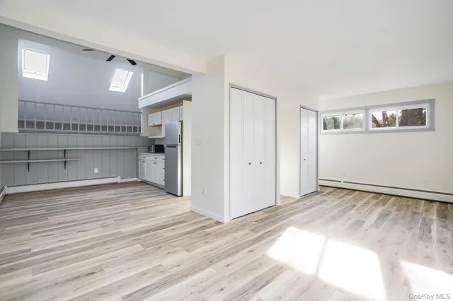 a kitchen with white cabinets and white appliances