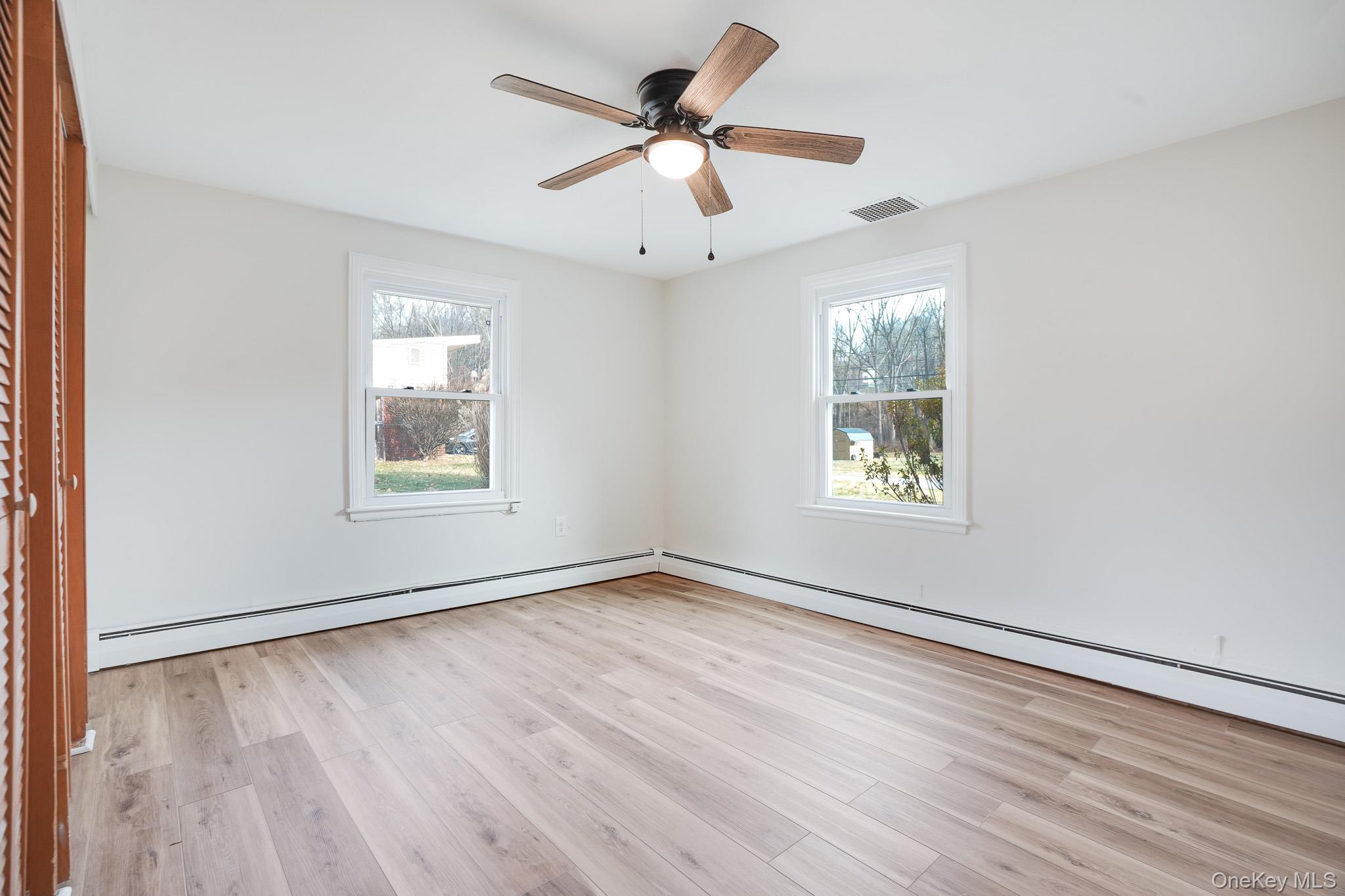 3 Pond Road Hyde Park, NY 12601 - Photo 7 of 34 an empty room with wooden floor chandelier fan and windows