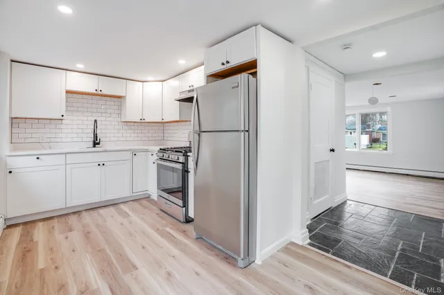 a kitchen with stainless steel appliances a stove a refrigerator and cabinets