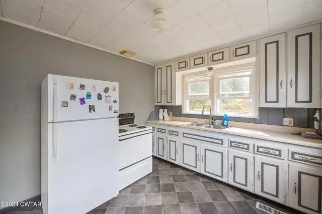 a white kitchen with sink and white cabinets