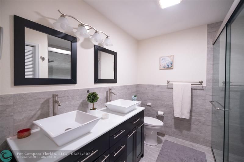 1224 Northwest 15th Street Boca Raton, FL 33486 - Photo 16 of 20 a bathroom with a toilet a sink a mirror a lamp and window