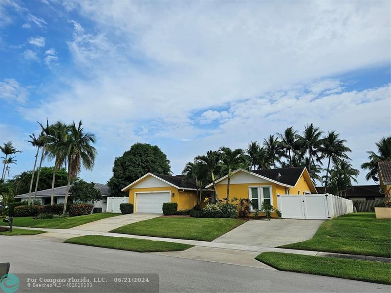 1224 Northwest 15th Street Boca Raton, FL 33486 - Photo 19 of 20 a front view of a house with a garden and yard