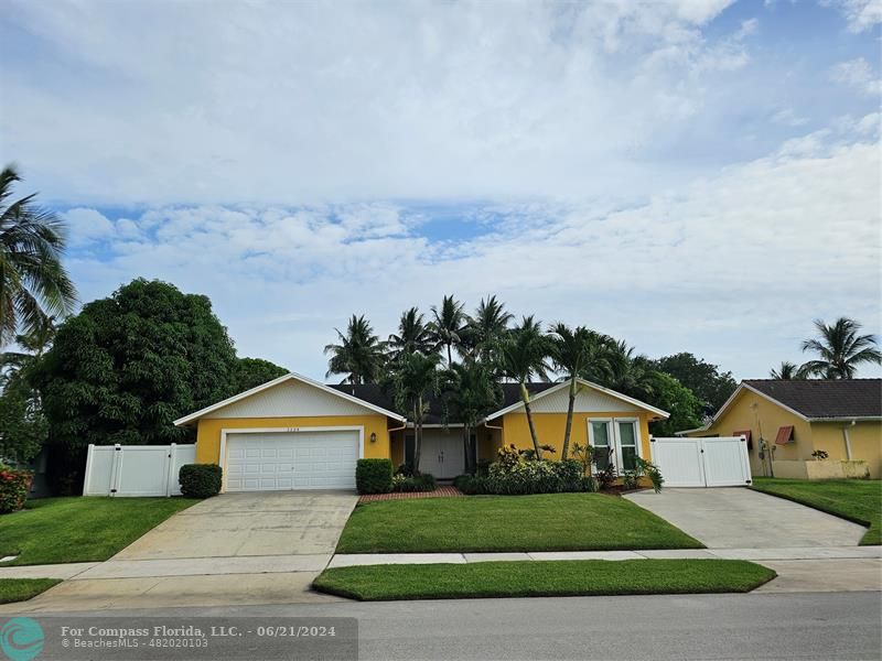 1224 Northwest 15th Street Boca Raton, FL 33486 - Photo 2 of 20 a front view of a house with a yard and garage