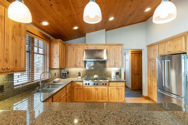 a large kitchen with granite countertop a stove a sink and a refrigerator