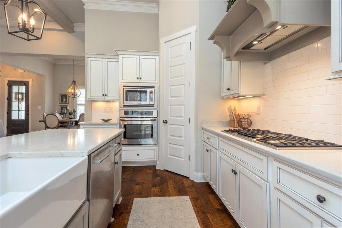608 Cypress Run Cove Collierville, TN 38017 - Photo 14 of 40 Kitchen with extractor fan, dark wood-style floors, stainless steel appliances, suspended lighting, and white cabinets