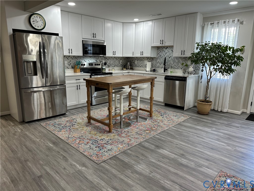 305 Myrtle Street, Unit A Ashland, VA 23005 - Photo 10 of 59 a kitchen with stainless steel appliances kitchen island granite countertop a refrigerator stove microwave and sink