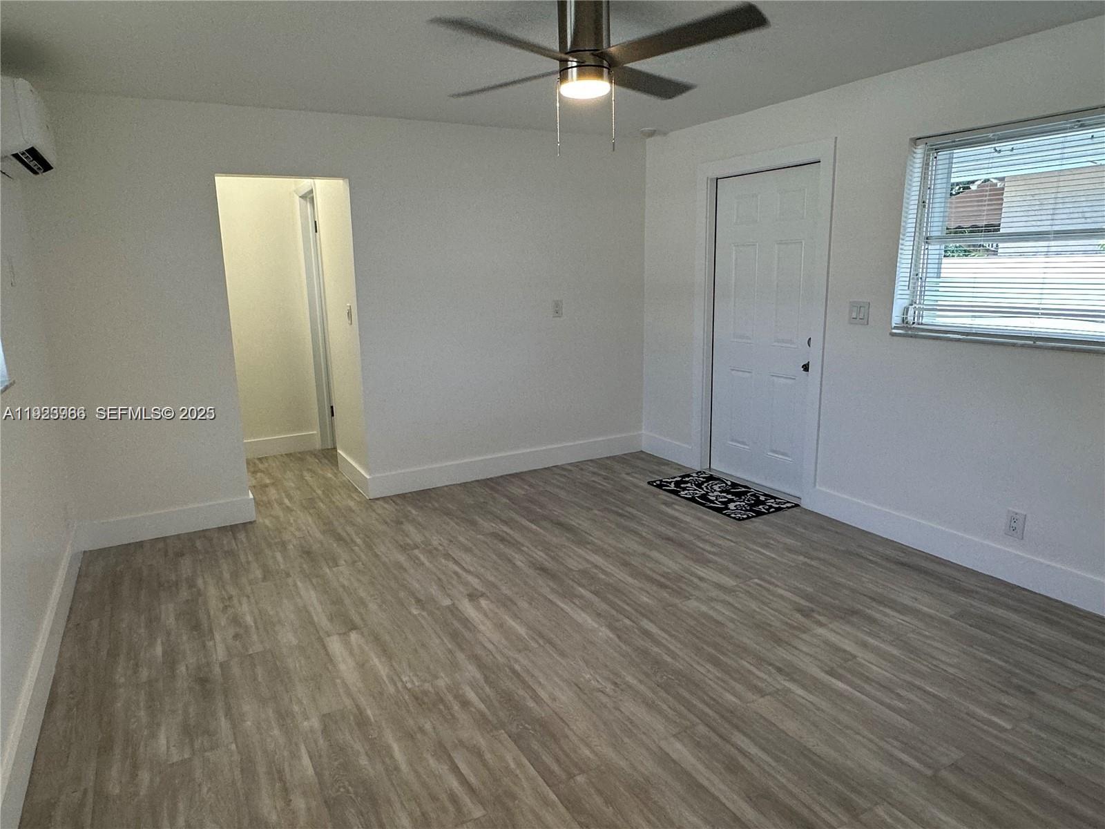28 Southeast 4th Street Dania Beach, FL 33004 - Photo 11 of 14 an empty room with wooden floor and windows
