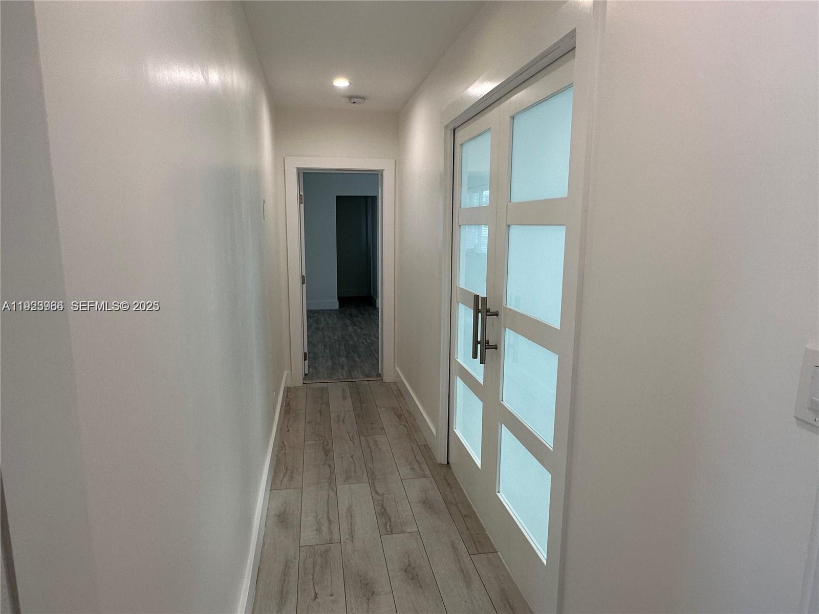 28 Southeast 4th Street Dania Beach, FL 33004 - Photo 7 of 14 a view of a hallway with wooden floor and a bathroom