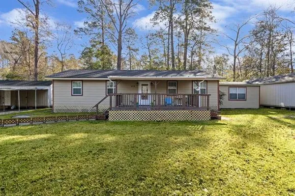 a view of a house with a yard and large tree
