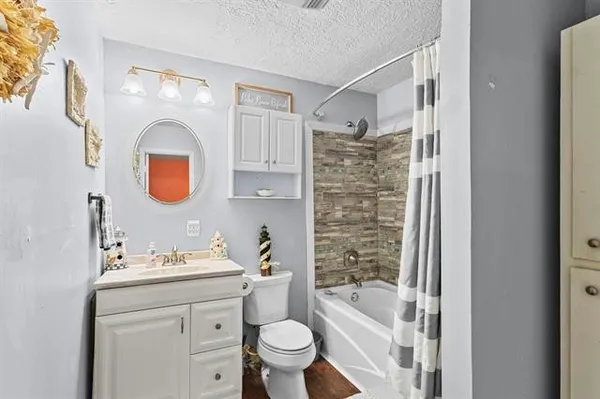 a bathroom with a bathtub sink mirror vanity and toilet