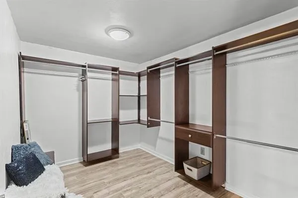 a view of walk in closet with clothes and shoes