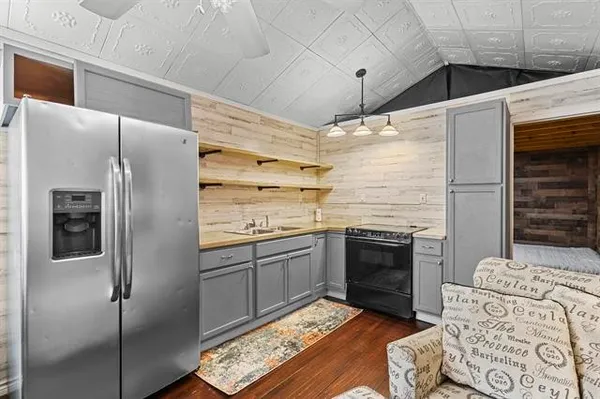 a kitchen with stainless steel appliances kitchen island granite countertop a refrigerator and a stove top oven