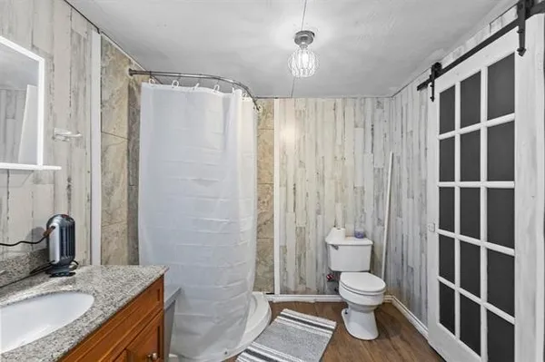 a bathroom with a granite countertop sink toilet and shower