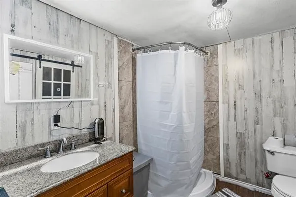a bathroom with a granite countertop sink toilet and shower