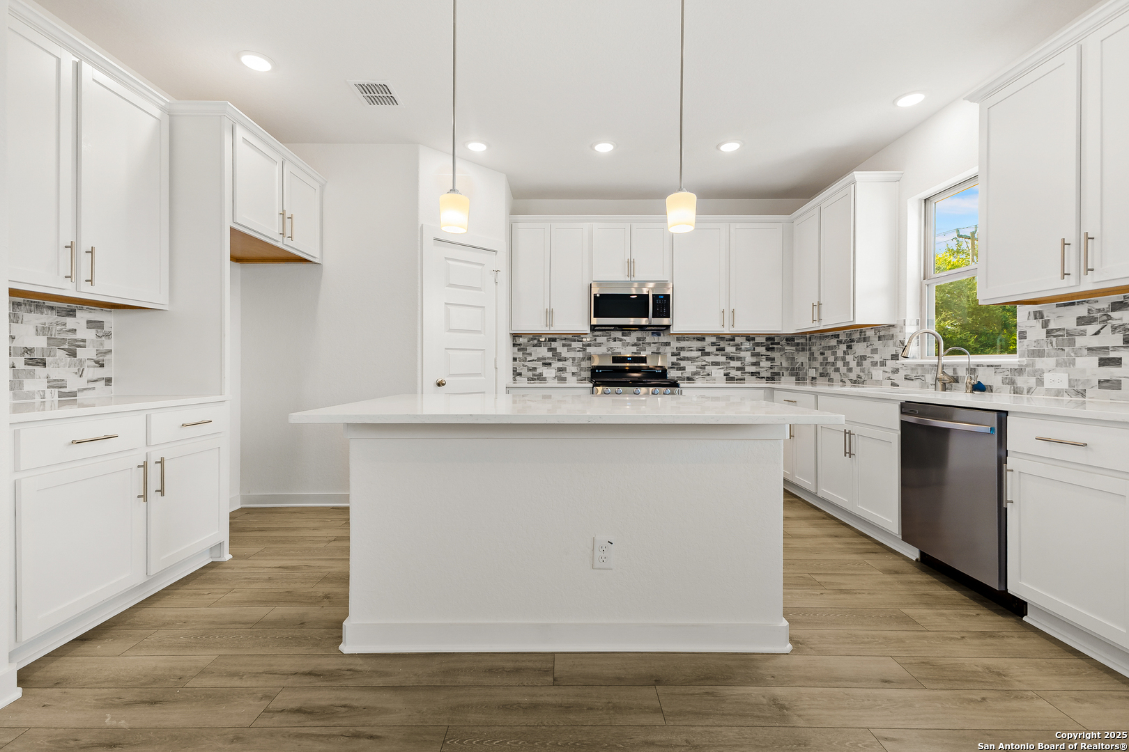 116 Vertex Loop San Antonio, TX 78238 - Photo 13 of 27 a kitchen with kitchen island white cabinets appliances and a window