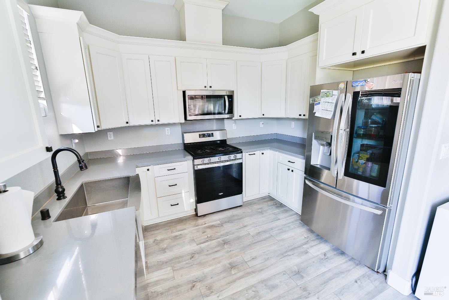 1331 Ridgecrest Court Santa Rosa, CA 95403 - Photo 3 of 19 a kitchen with white cabinets and stainless steel appliances
